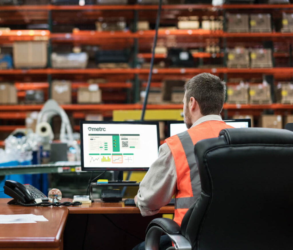 A worker in a warehouse using Metrc software